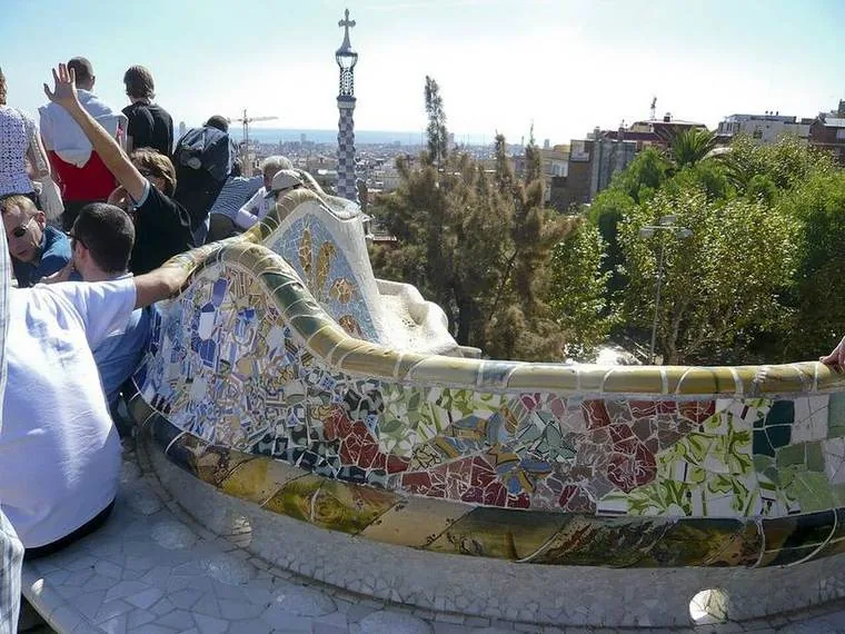 Banco ondulado de trencadís del Park Güell con vistas de Barcelona